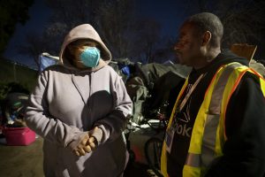 Rayna Burton, left, who is experiencing homelessness, speaks with Sacramento Steps Forward Coordinated Entry Specialist, Darrelle Weaver, near her camp on X Street during the Homeless Point-In-Time (PIT) Count on Feb. 24, 2022